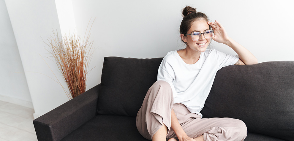 woman smiling sitting on sofa. weed dispensary. cannabis canada. weeds online. 