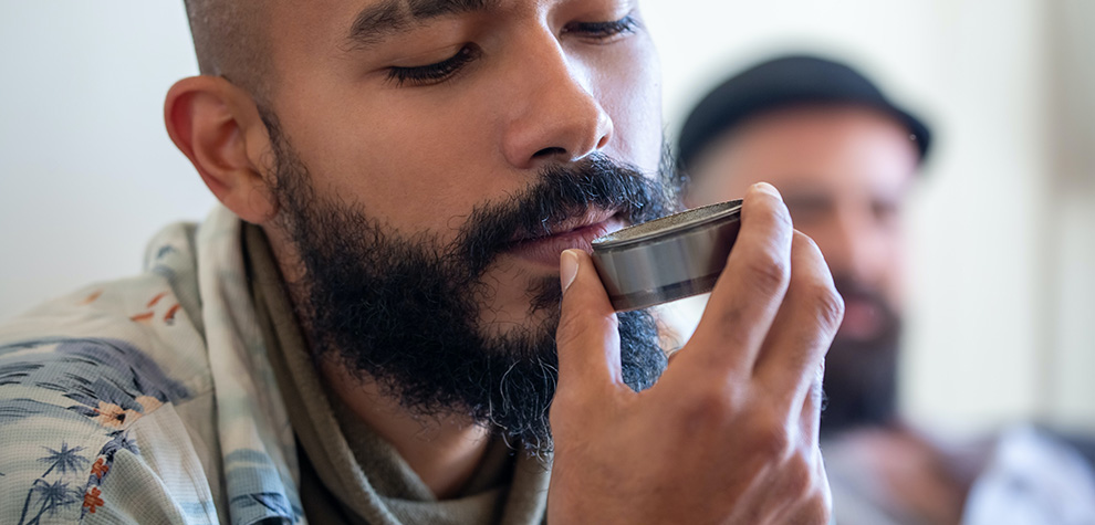 Man smelling grinder with Tom Ford strain weed. canada dispensary. weed shop online. cannabis online. Dispencary.