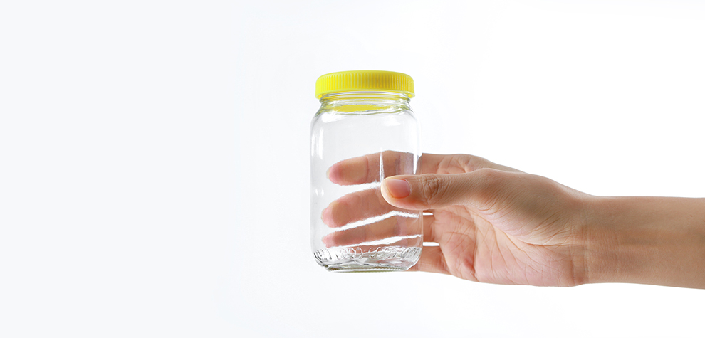 Hand holding empty glass jar suited for BC cannabis budget buds. Moon Rock weed for sale. Online dispensary for mail order weed Canada.