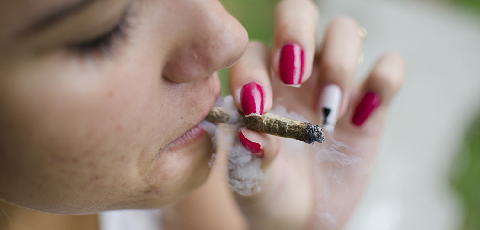 Woman smoking a joint of Jet Fuel Gelato strain weed from MMJ Express BC cannabis dispensary.