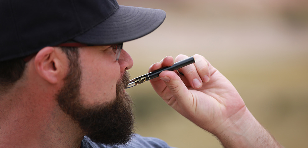 man using a weed vape pen with vape carts from Low Price Bud online dispensary.