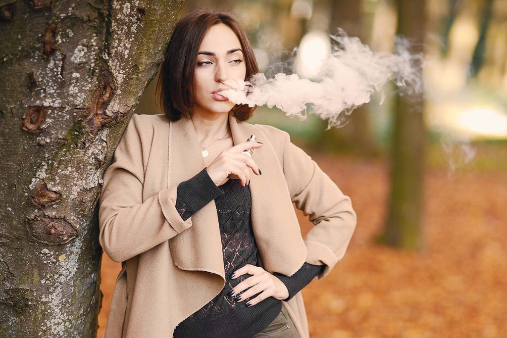 Woman vaping weed with a disposable THC vape pen from MMJ Express online dispensary Canada to buy weed online.
