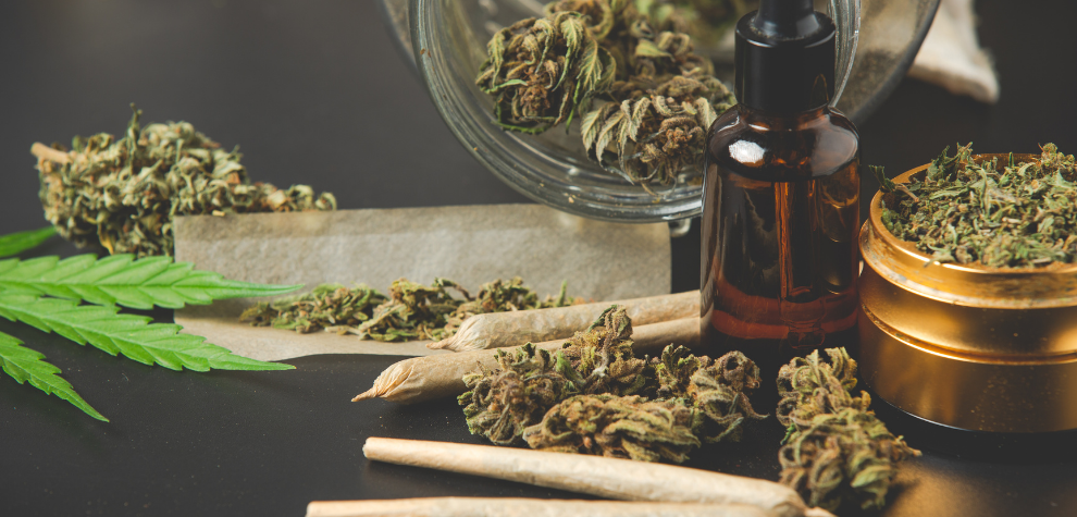 Assorted cannabis products including pre-rolls, buds, oil dropper, and grinder, showcasing variety from a weed store online