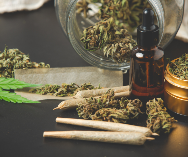 Assorted cannabis products including pre-rolls, buds, oil dropper, and grinder, showcasing variety from a weed store online