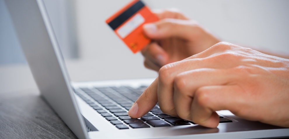 Person using a credit card to buy weed online in Canada through a laptop