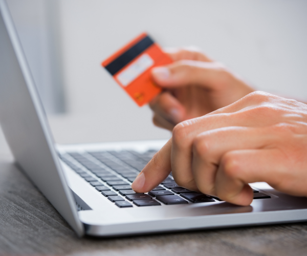 Person using a credit card to buy weed online in Canada through a laptop