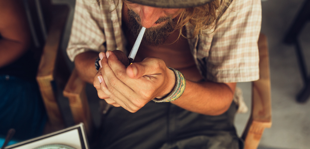 Man lighting a joint, representing a relaxed way to enjoy the potent effects of the Chemdawg weed strain