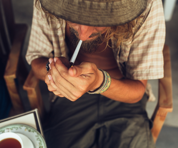 Man lighting a joint, representing a relaxed way to enjoy the potent effects of the Chemdawg weed strain
